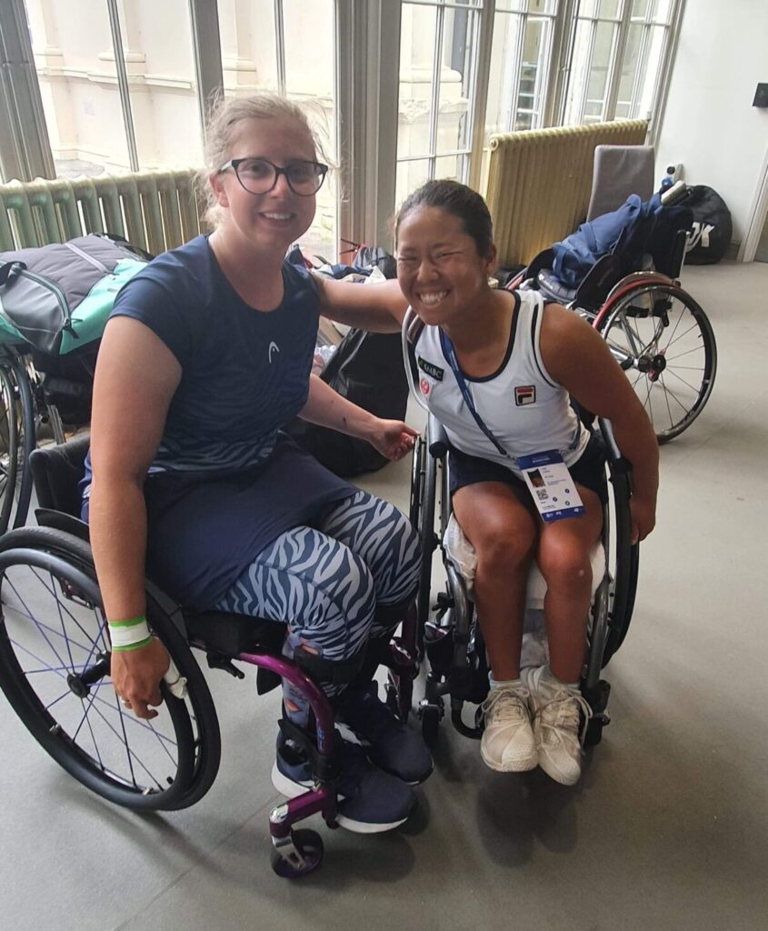 Abbie Breakwell with Yui Kamiji in the players area in Eastbourne after their match. They are both smiling and are hugging each other