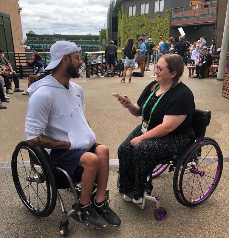 Heath Davidson is interviewed by Gemma Stevenson on the media balcony at Wimbledon with Centre Court in the background